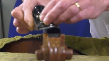 bir luthier bir çello dokunuş yerini alır.