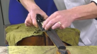 bir luthier bir çello dokunuş yerini alır.