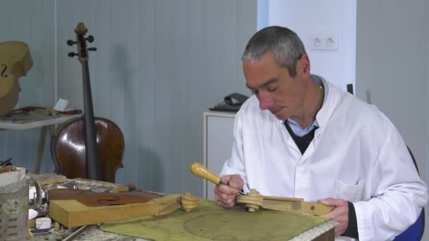 Luthier esculpe una cabeza de cello — Vídeos de Stock