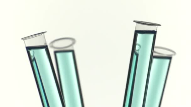 Test tube filled with blue liquid, pouring a drop of water — Stock Video