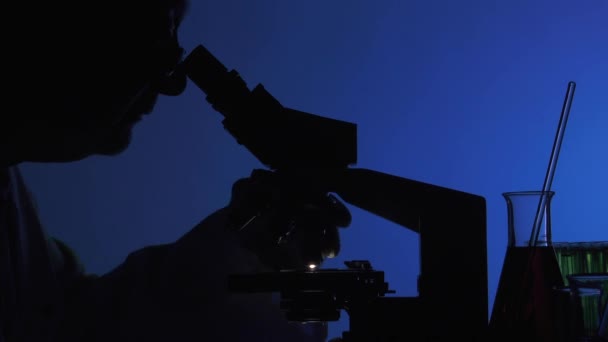Hombre manipulando un microscopio — Vídeo de stock