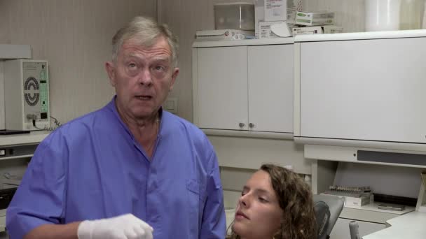 Dentist adjust the chair of his patient — Stock Video