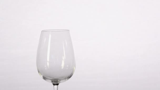 Roze wijn stroomt in glas — Stockvideo