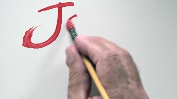 Menschliches Handschriftwort "joyeux noel" auf französisch, mit roter Gouache — Stockvideo