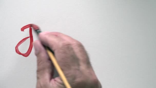 Menselijke hand schrijven woord "je t'aime" in het Frans, met rode gouache — Stockvideo