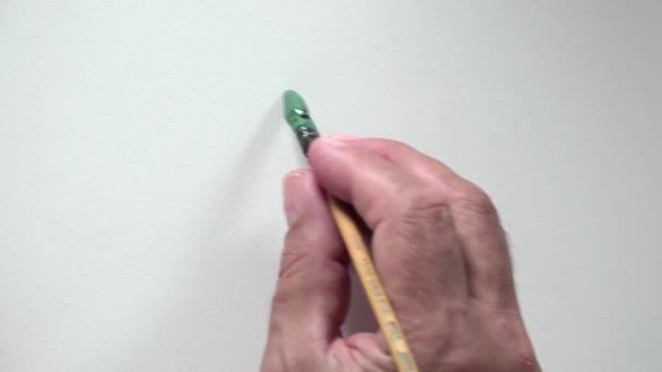 Mão humana escrevendo palavra "GO" com guache verde — Vídeo de Stock
