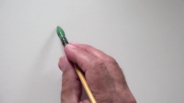 Human hand writing word "BUT" with green gouache — Stock Video