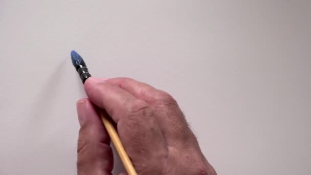 Mänsklig hand skriver ordet "Hej" med blå gouache — Stockvideo