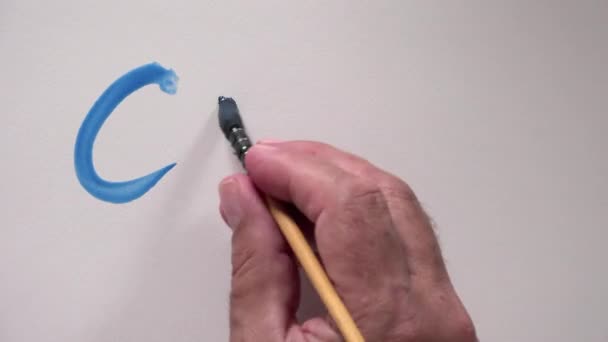 Human hand writing word "COOL" with blue gouache — Stock Video