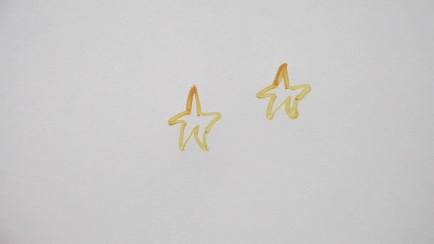 Mano humana dibujando muchas estrellas con gouache naranja — Vídeos de Stock