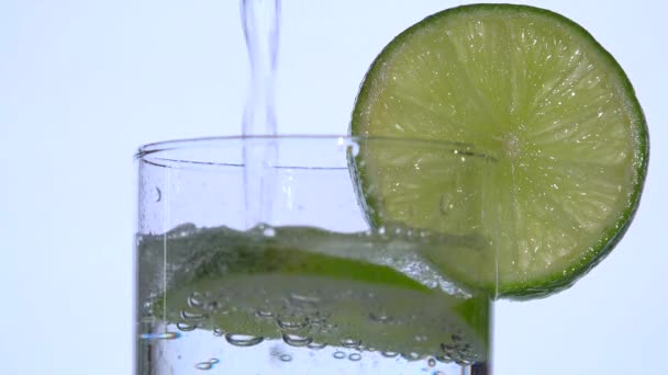 Eau gazeuse coulant près d'une tranche de citron — Video