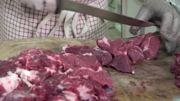 Um açougueiro cortando cubos de carne — Vídeo de Stock