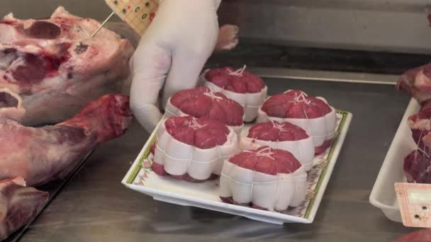 Der Metzger legt seine Produkte in einer Kühlvitrine ab — Stockvideo