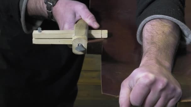 Artesano de artículos de cuero trabajando en su taller — Vídeos de Stock