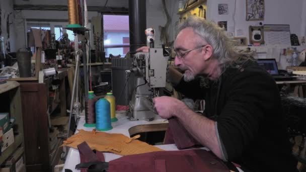 Leather goods craftsman at work in his workshop — Stock Video
