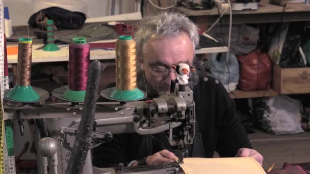 Artesano de artículos de cuero trabajando en su taller — Vídeos de Stock