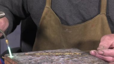 bir sanatkâr kuyumcu bilezik oluşturur