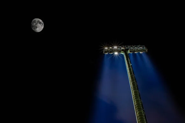 Stadion floodlightswith księżyc noc ciemna na tle nieba — Zdjęcie stockowe