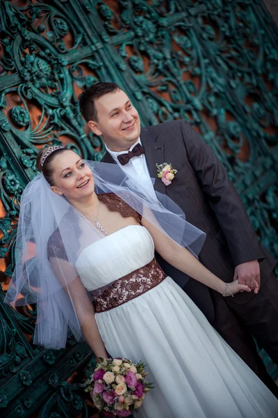 Wedding couple at the wrought-iron gates