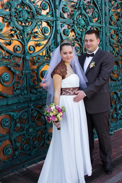 Wedding couple at the wrought-iron gates