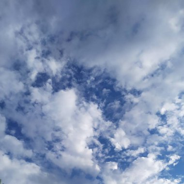 Mavi gökyüzünde yırtık pırtık bulutlar var. 