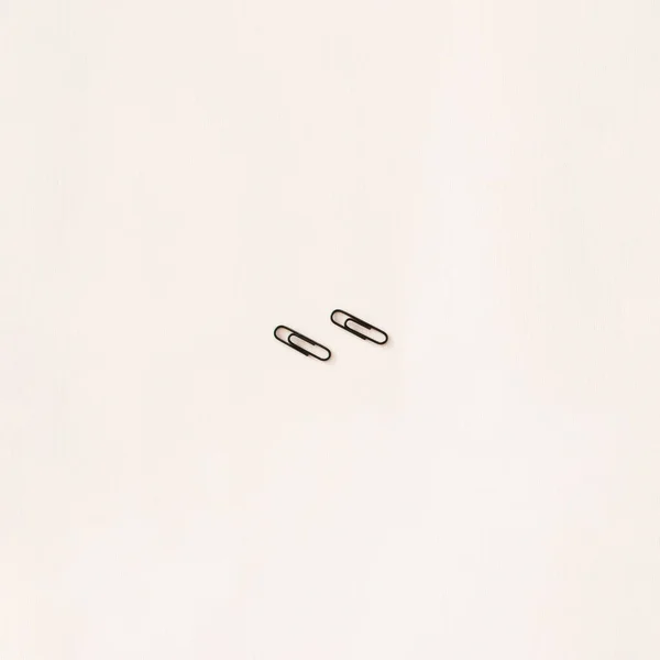 Two Little Black Paper Clips White Surface Minimal Art Idea — Stock Photo, Image