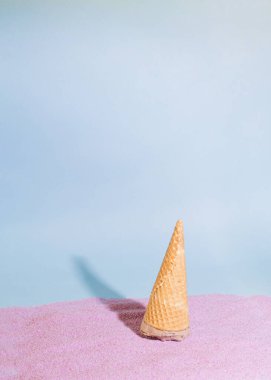 baş aşağı duran mavi arkaplanda güneşli bir dondurma. Mor, soyut, mor kum tasarımı.