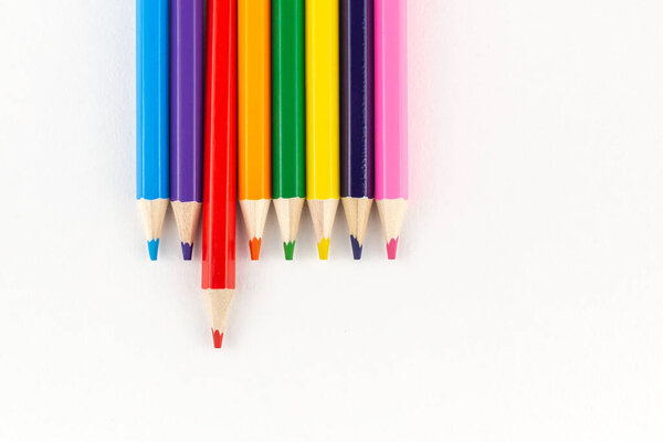 Bright colored pencils on a white paper background