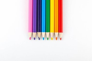 Renkli kalemler beyaz arkaplanda bir satırda yatıyor.