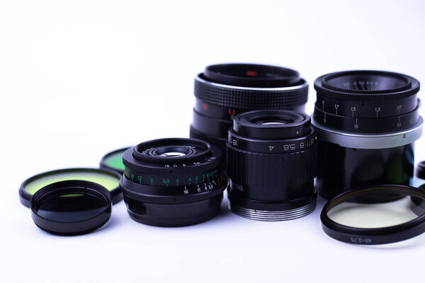 set of old-vintage lenses and color photo filters on a white background.