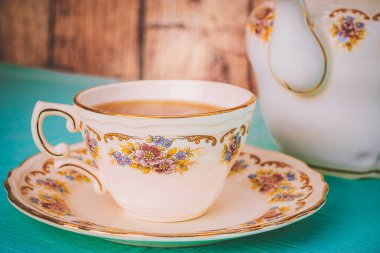 Gün batımında bir fincan çay ve güzel bir porselen çaydanlık.