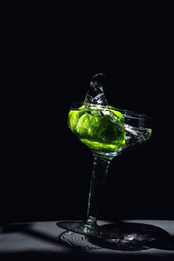Kristal bardağa düşen limonlar su sıçratıyor.