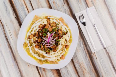 Bir restoranın masasında kremalı, tavuklu ve soğanlı yeşil soslu 