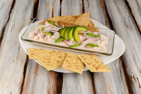 Bir restoran masasında, Avokado ve kraker ile yakın plan Peru ceviche 'si gösterilir.