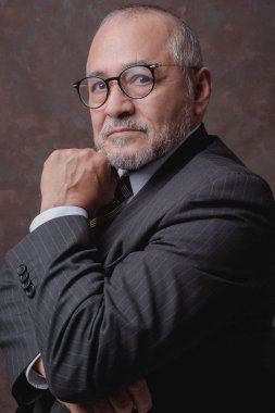 Koyu kahverengi çizgili ve şapkalı bir beyefendi kameraya poz veriyor.