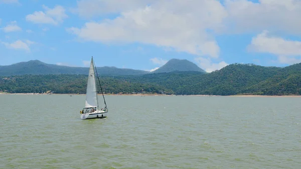 Meksika, Valle de Bravo 26 Mart 2021, gölün sularında yüzen bir yelkenli, arka planda güzel bir kompozisyon.