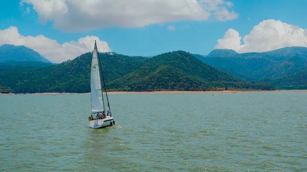 Meksika, Valle de Bravo 26 Mart 2021, gölün sularında yüzen bir yelkenli, arka planda güzel bir kompozisyon.