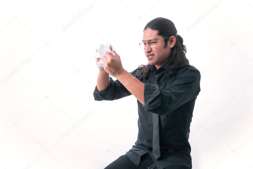 Man on white background. he finishes tearing up a page because he got angry about something he read. he is frustrated. dressed in formal clothes. White space. Man gesticulating.