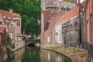 Bruges, Belçika. Brugge. Arka planda ortaçağ köprüsü olan bir nehir manzarası. Flanders