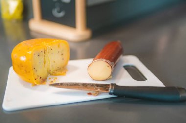 Yakın plan peynir ve sosis koleksiyonu, Hollanda 'da inek sütünden yapılmış olgun Hollanda peyniri dilimleri..