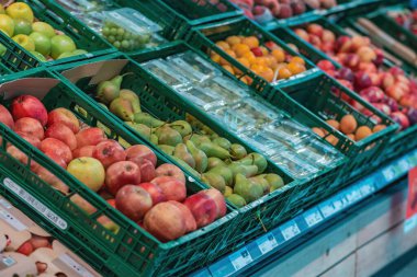 Süpermarkette taze sebzeler, meyve ve sebzelerle dolu bir koridor. Çok çeşitli sağlıklı seçenekler..