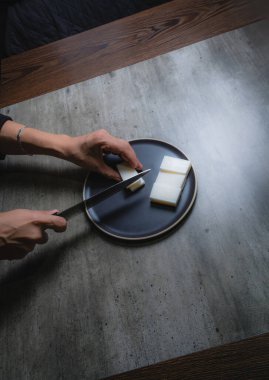 Evde, doğal banyo sabunu yapmak için organik sabun macunu kesen bir kadının ellerini görebilirsiniz. Ev yapımı. Yüzde yüz doğal..