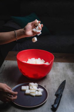 Evde, doğal banyo sabunu yapmak için organik sabun macunu kesen bir kadının ellerini görebilirsiniz. Ev yapımı. Yüzde yüz doğal..