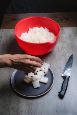 Evde, doğal banyo sabunu yapmak için organik sabun macunu kesen bir kadının ellerini görebilirsiniz. Ev yapımı. Yüzde yüz doğal..