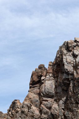 Mavi gökyüzünün arka planında eski bir kaya. Doğa duvar kâğıdı
