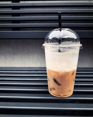 Arka plandaki buzlu kahve bardağında.