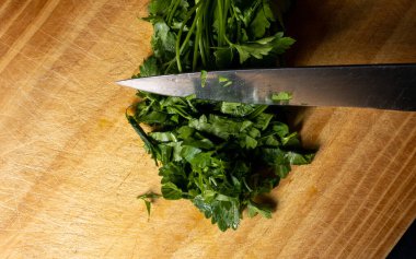 Maydanoz, tahtaya saplanmış bir bıçakla soldan sağa ışık tutuyor. Baharat evde ve restoranlarda yemek pişirirdi. Genel olarak yemeğe tuzlu bir tat katardı.