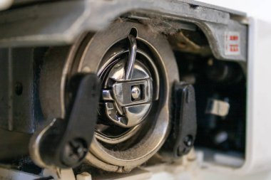 Dikiş makinesinin alt iç kısmının ayrıntıları iğne ile birlikte kullanılmak üzere yerleştirilir. Evde ya da fabrikada giysi ve ayakkabı yapımında kullanılır..