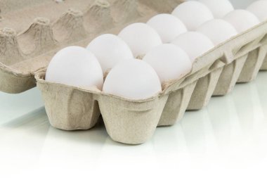 Yansıtıcı beyaz arkaplanda yumurta kutusu.