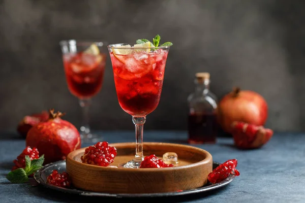 Pomegranate refreshing summer cocktail on dark background. Summer cocktail